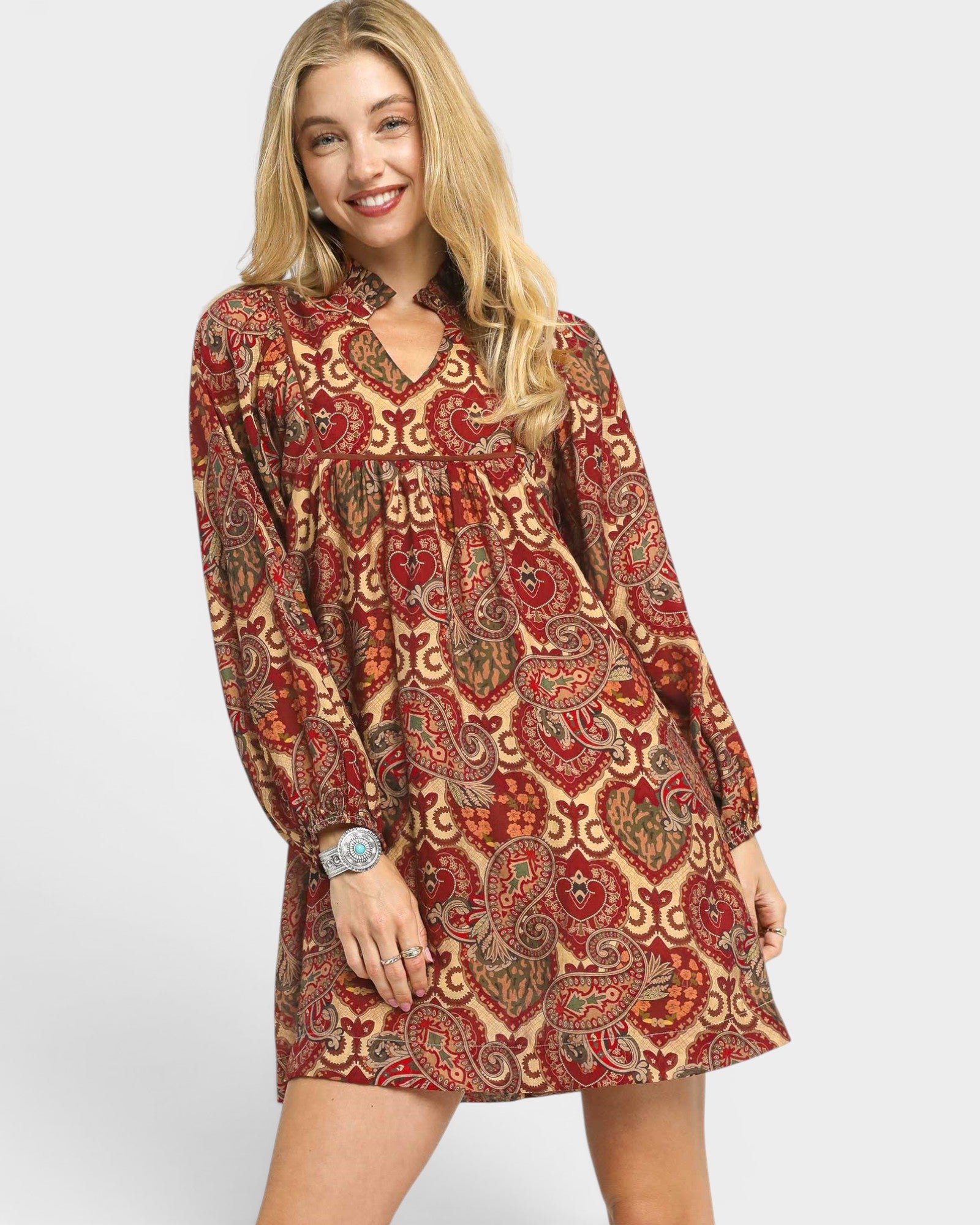 Woman wearing a patterned dress on a plain background