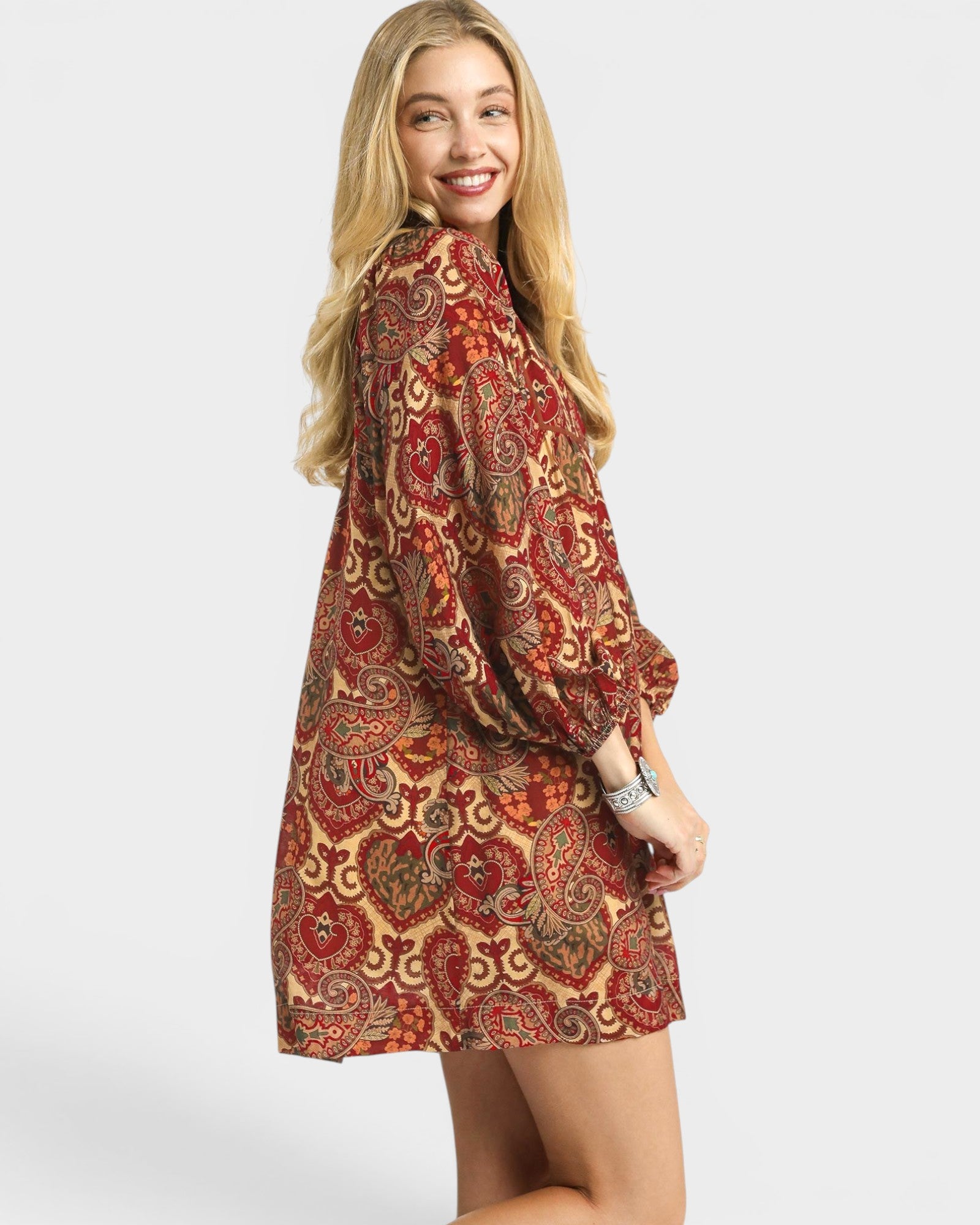 Woman wearing a patterned dress on a white background