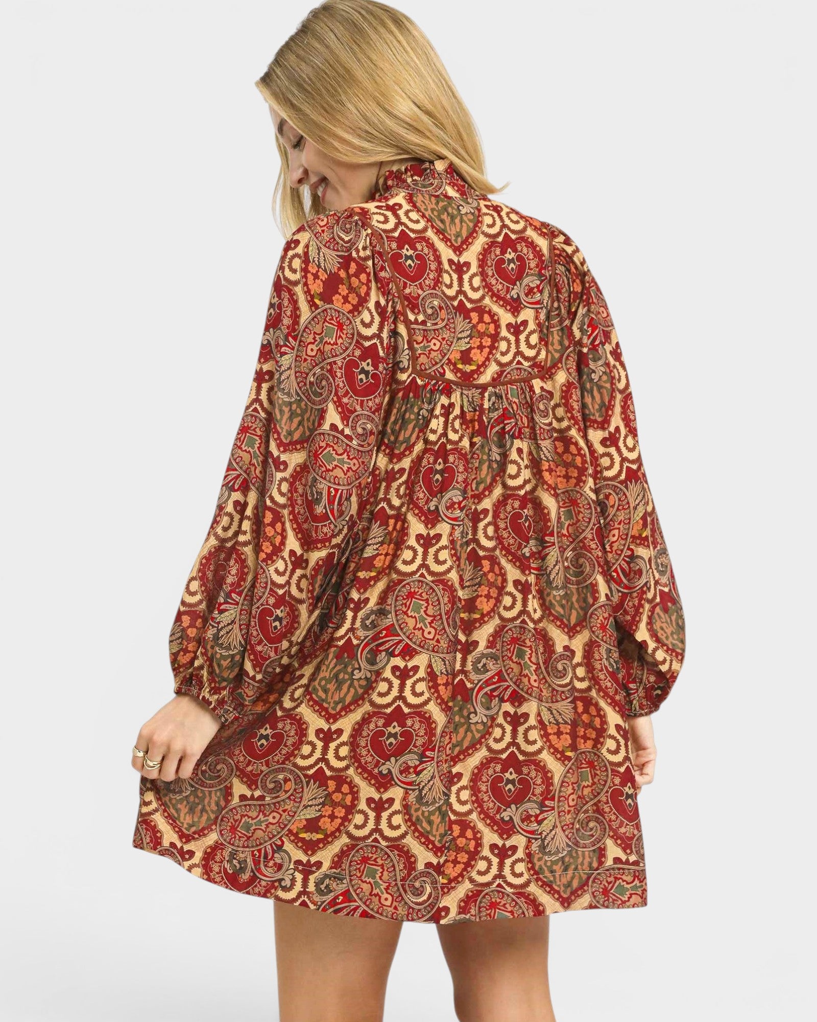 Woman wearing a patterned dress on a plain background