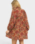 Woman wearing a patterned dress on a plain background