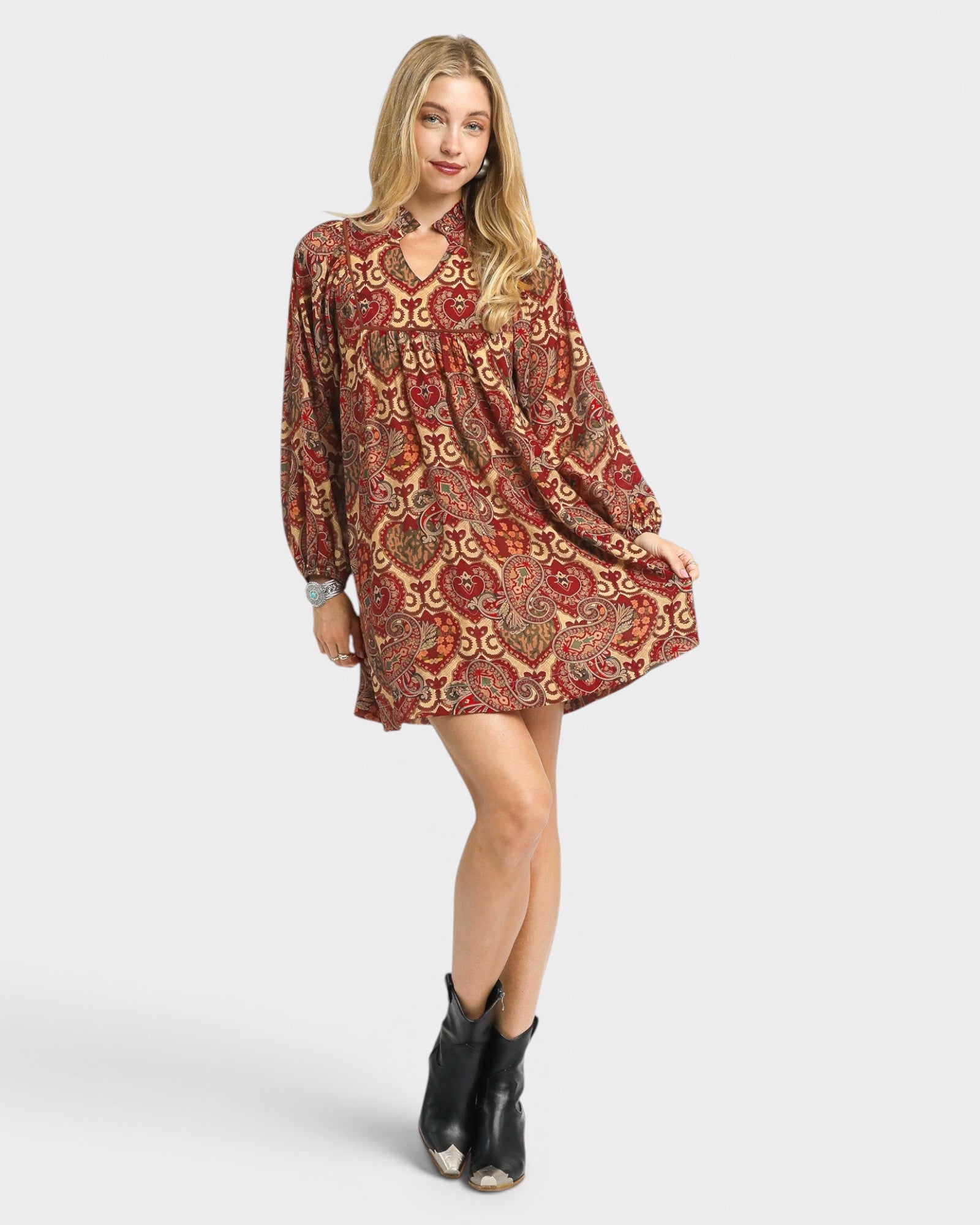 Woman wearing a patterned dress with long sleeves on a white background