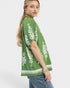 Woman wearing a green kimono-style top with white patterns on a white background