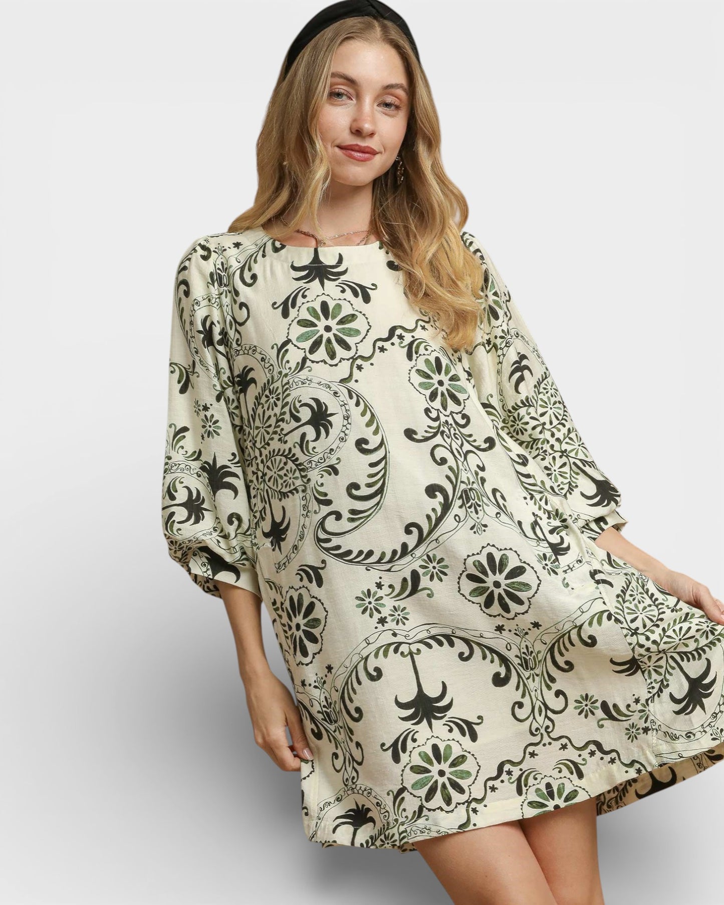 Woman wearing a patterned dress on a plain background