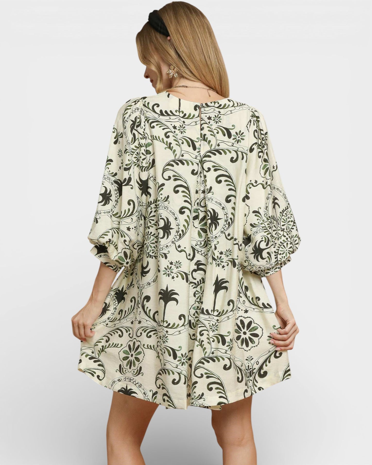 Woman wearing a patterned dress on a plain background