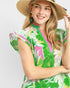Woman wearing a colorful floral dress and straw hat on a white background