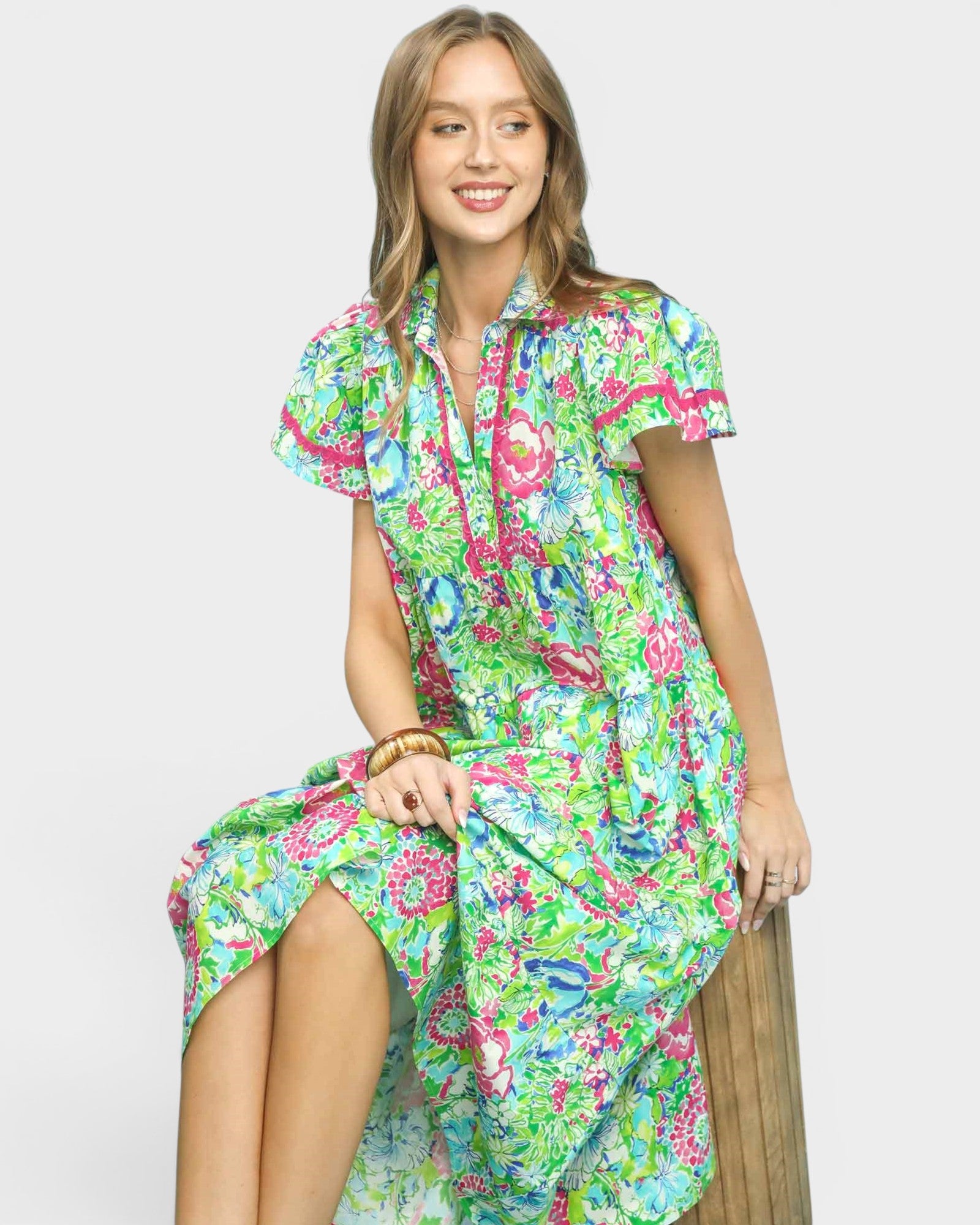 Woman wearing a colorful floral dress on a white background