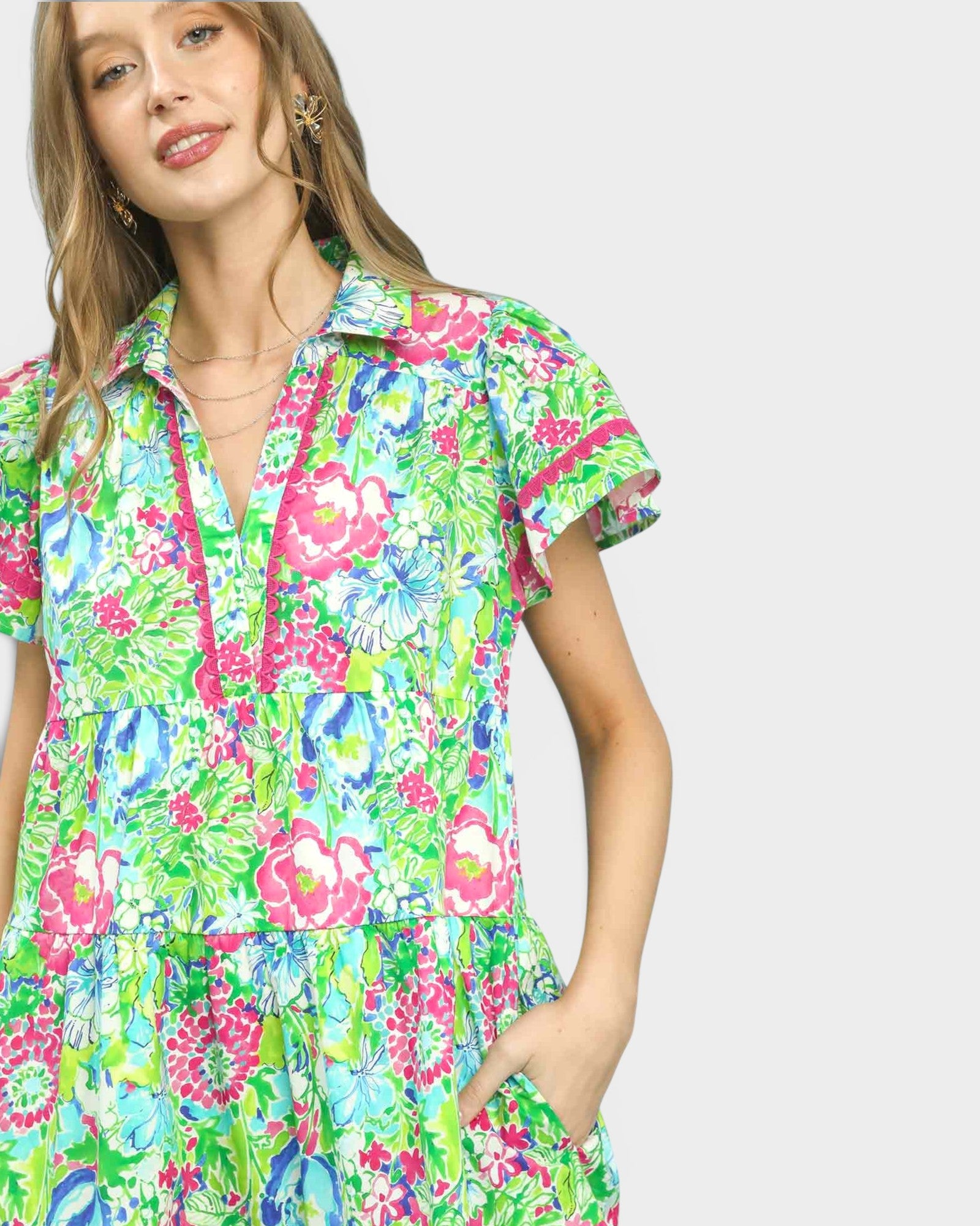 Woman wearing a colorful floral dress on a light gray background