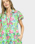 Woman wearing a colorful floral dress on a light gray background
