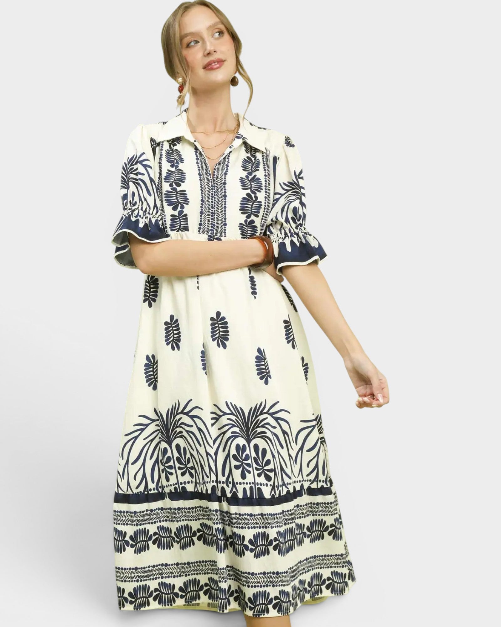 Woman wearing a white dress with black pattern on a white background