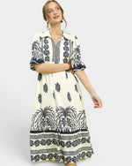 Woman wearing a white dress with black pattern on a white background