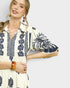 Woman wearing a patterned dress with a plain background