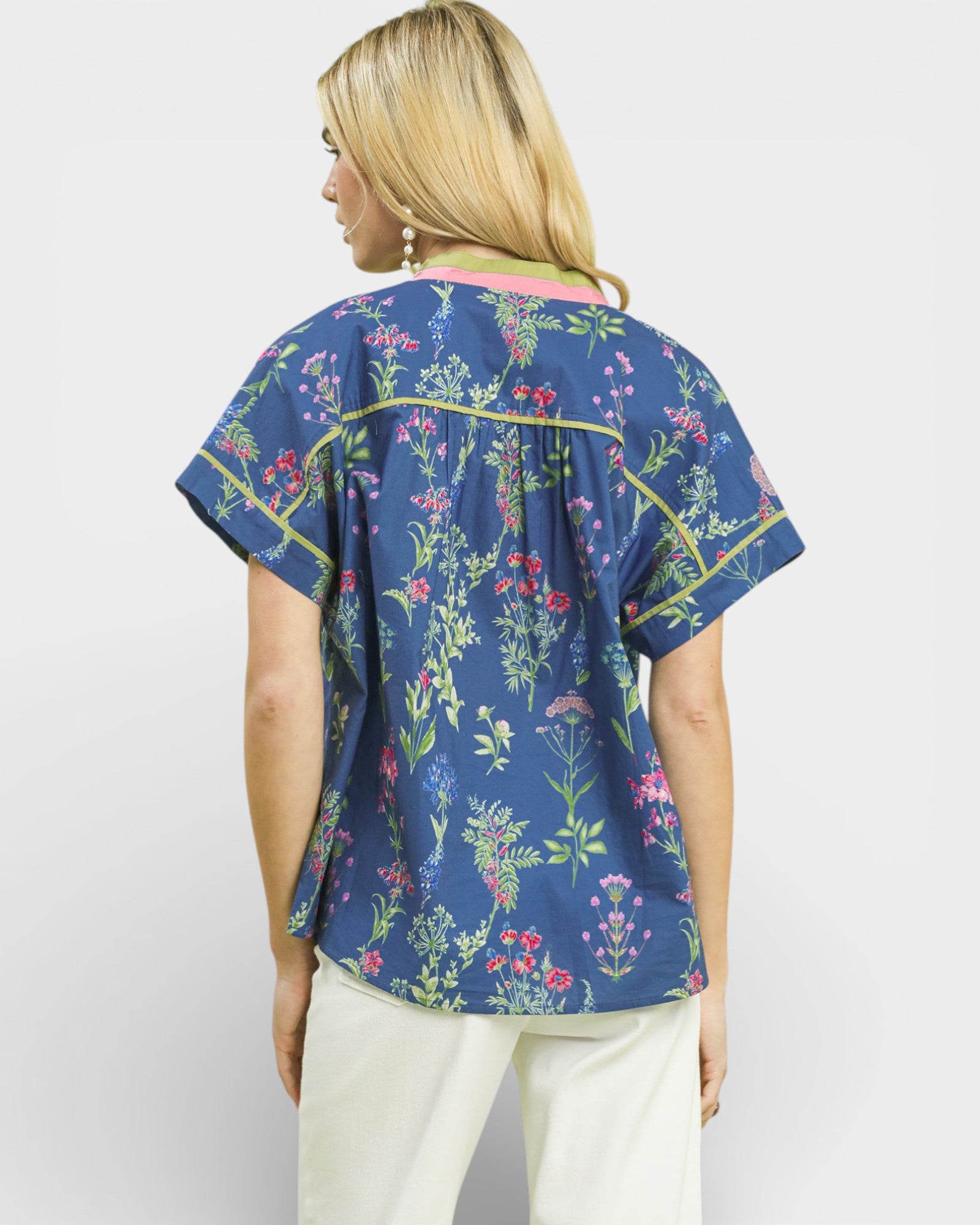 Woman wearing a blue floral blouse with a plain background