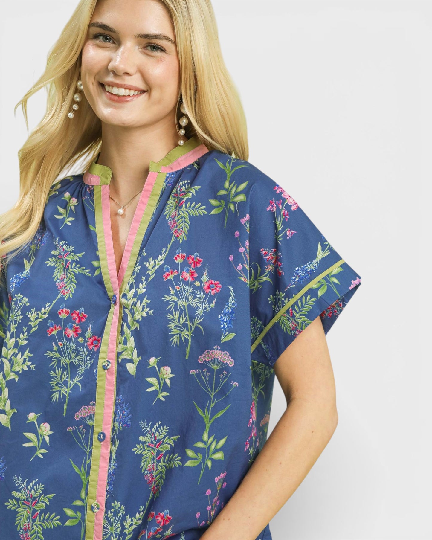 Woman wearing a blue floral patterned shirt on a white background