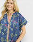 Woman wearing a blue floral patterned shirt on a white background