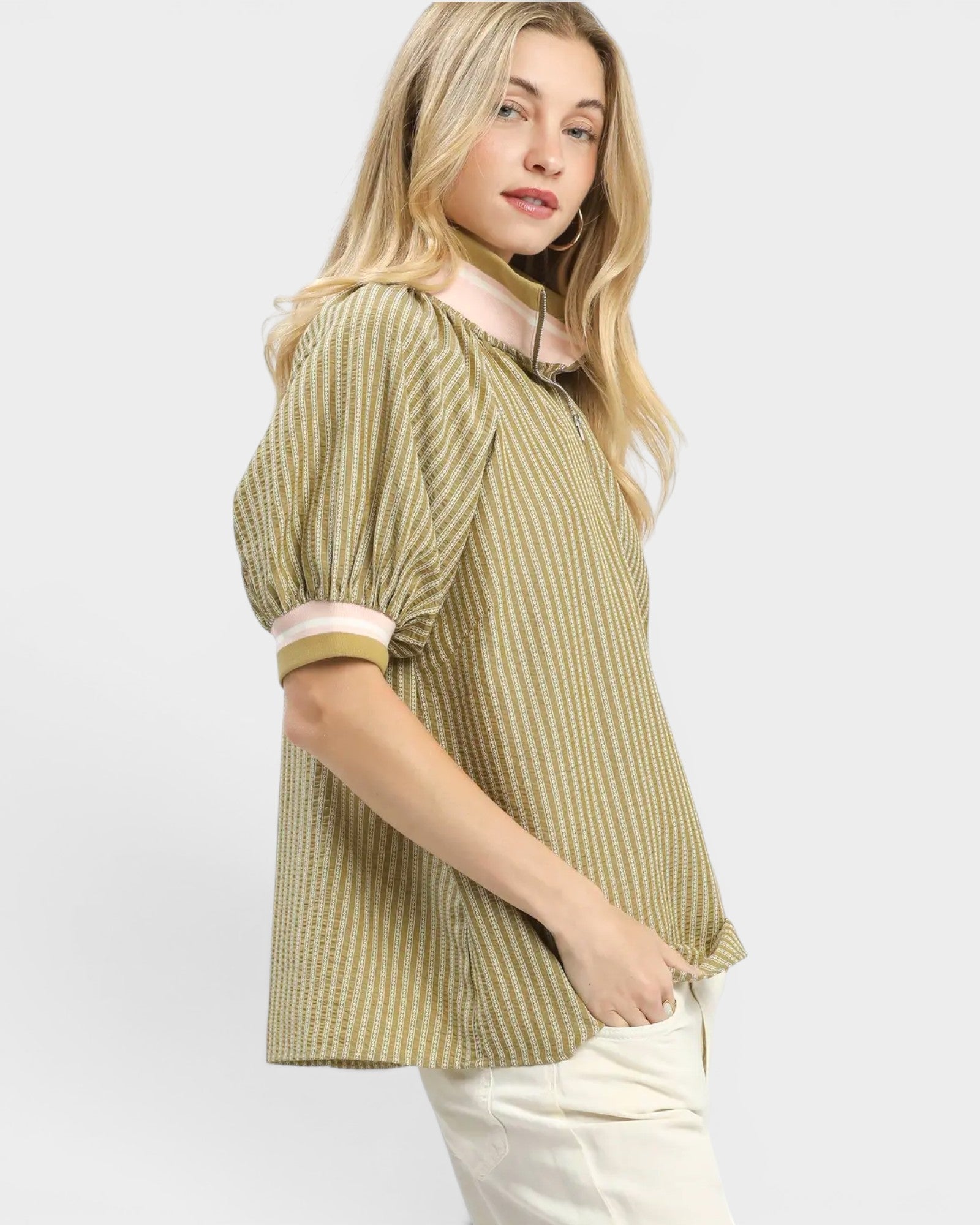 Woman wearing a green and white striped blouse on a white background