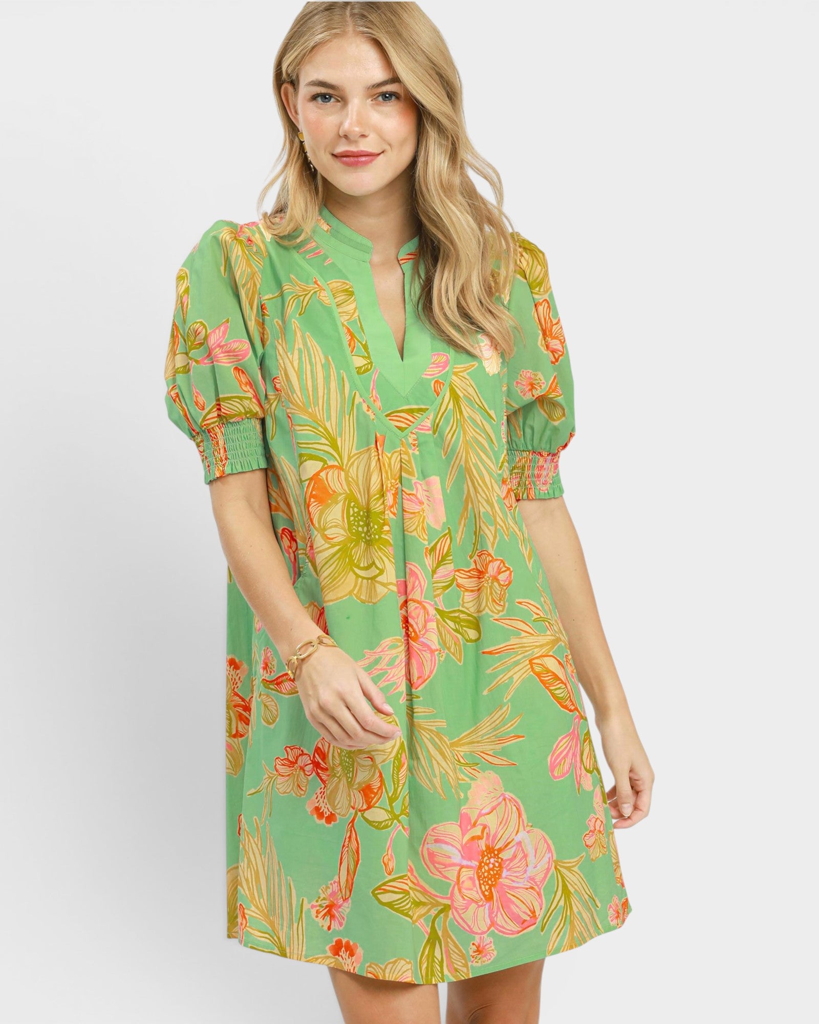 Woman wearing a green floral dress on a white background