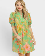 Woman wearing a green floral dress on a white background
