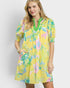 Woman wearing a yellow floral dress against a white background
