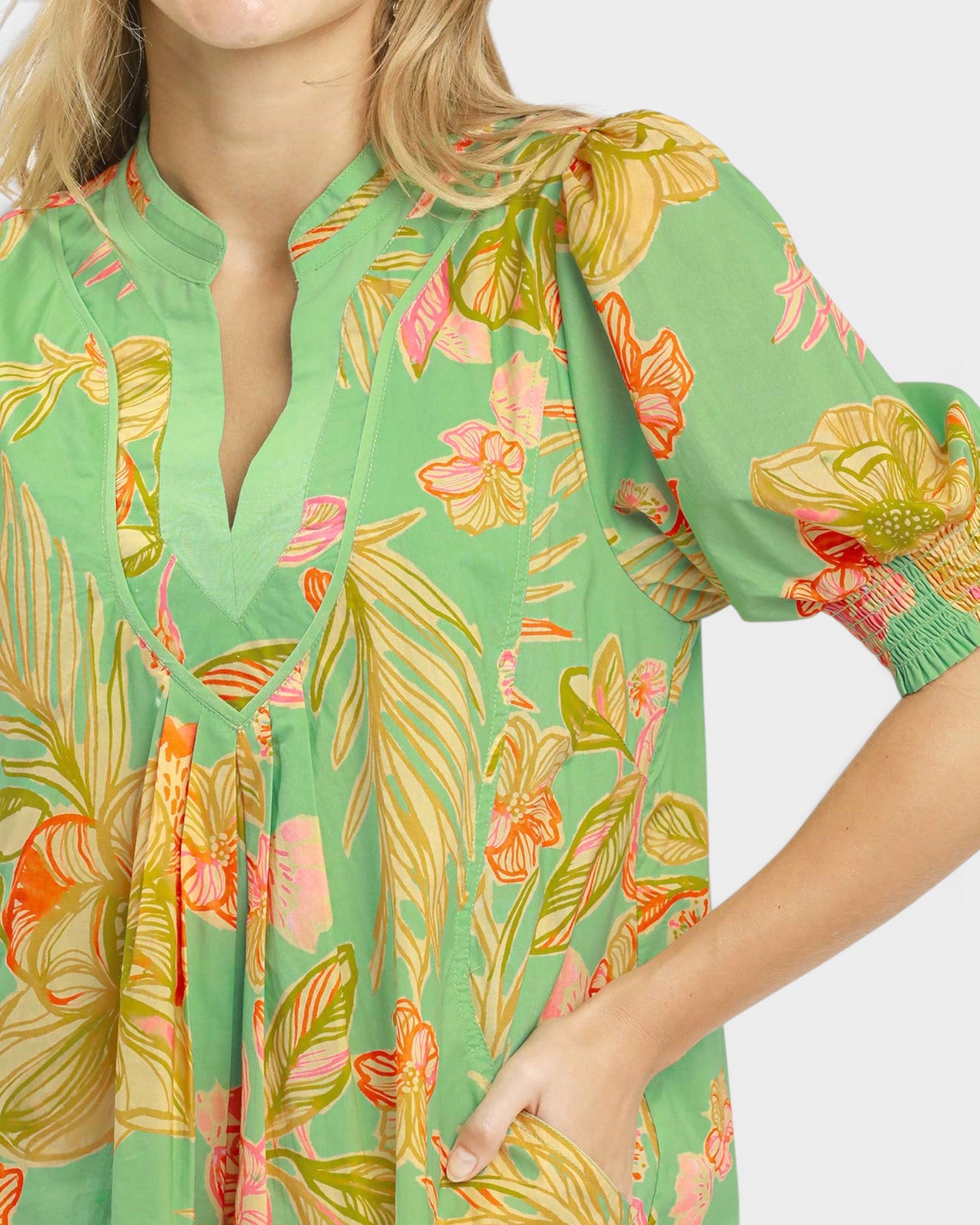 Green dress with colorful floral pattern on a white background