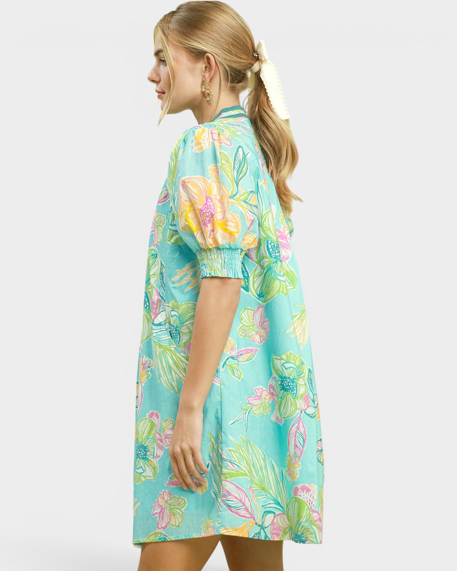 Woman wearing a colorful floral dress on a white background