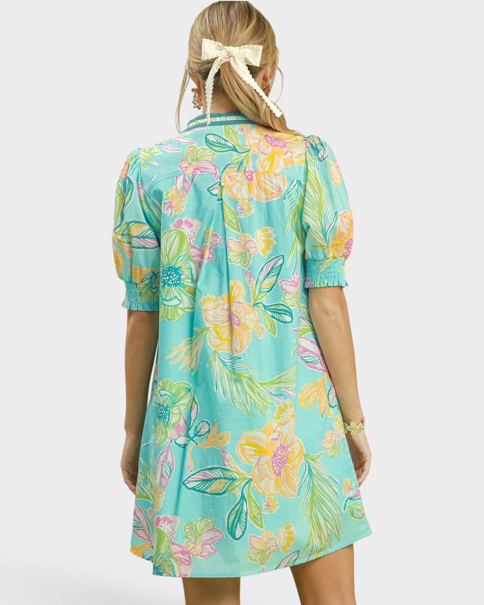 Woman wearing a colorful floral dress on a white background