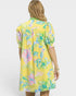 Woman wearing a yellow floral dress on a white background