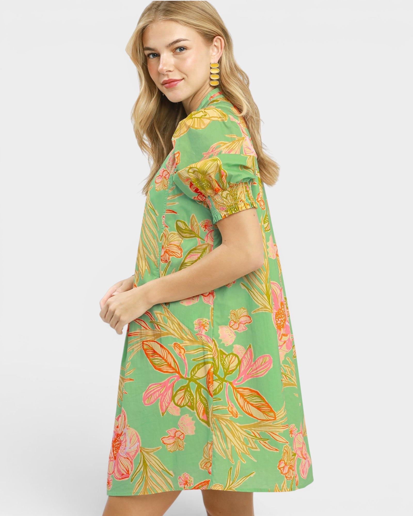 Woman wearing a green floral dress on a white background