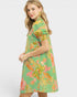 Woman wearing a green floral dress on a white background