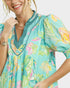 Woman wearing a colorful floral dress with a white background