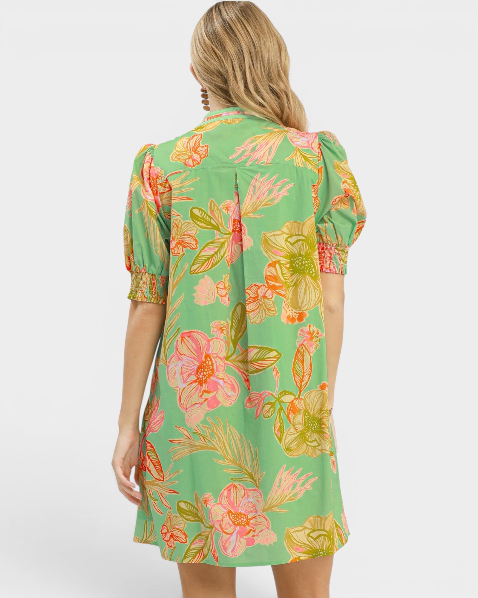 Woman wearing a green floral dress on a white background