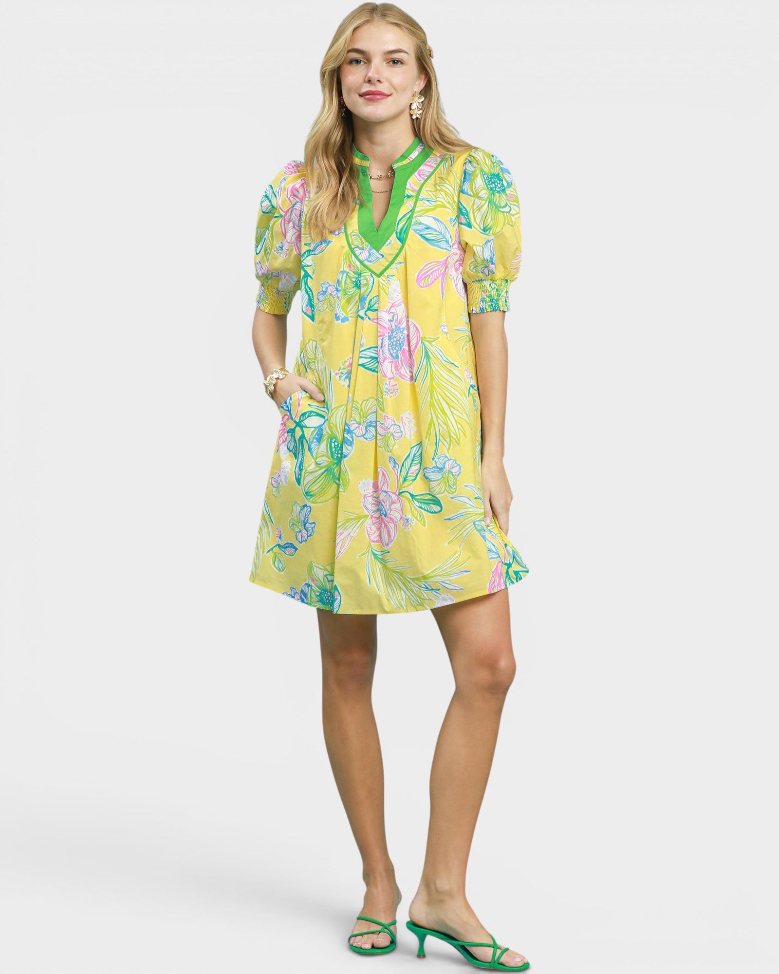 Woman wearing a yellow floral dress on a white background