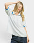 Woman wearing a striped shirt with blue accents on a plain background