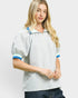 Woman wearing a striped shirt with blue accents on a plain background