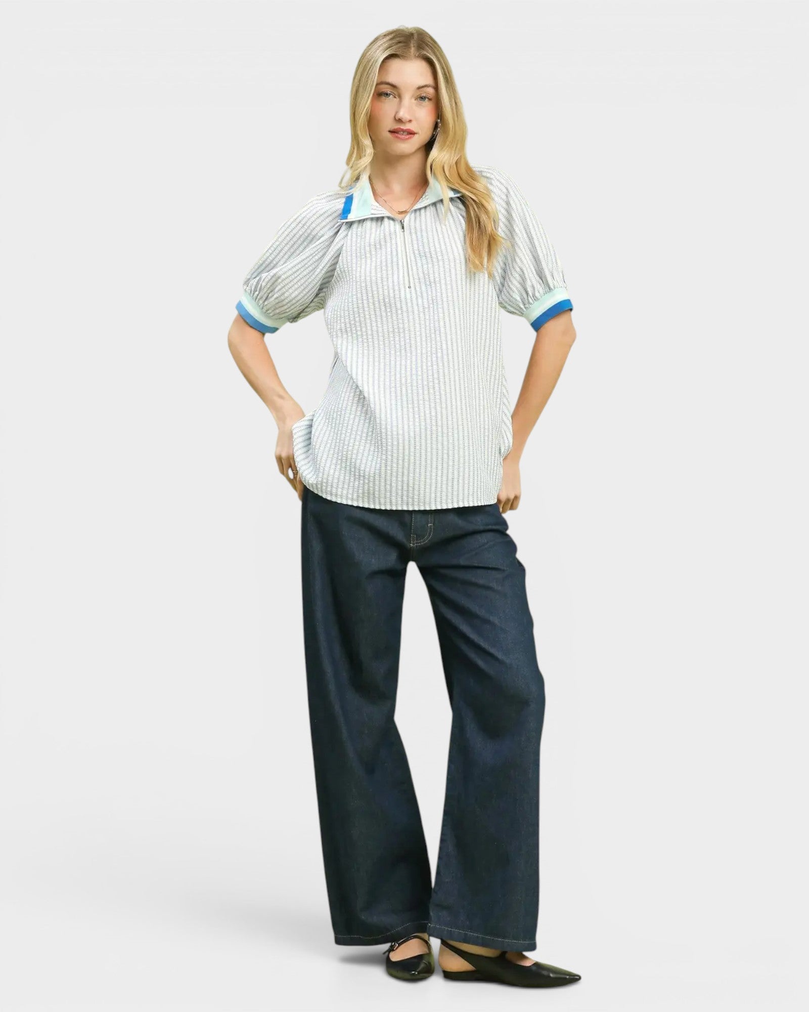 Woman wearing a striped shirt and dark pants on a white background