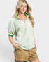 Woman wearing a light green striped shirt with yellow accents and beige shorts on a white background