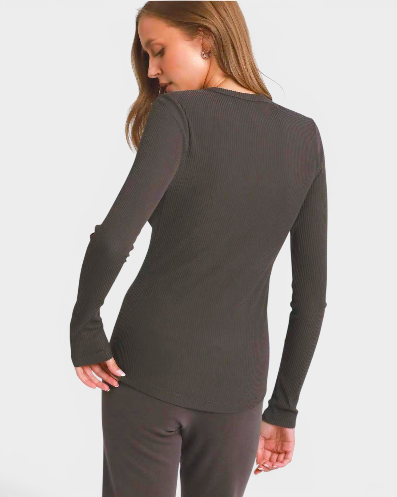 Person wearing a gray long-sleeve top on a white background