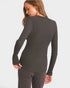 Person wearing a gray long-sleeve top on a white background