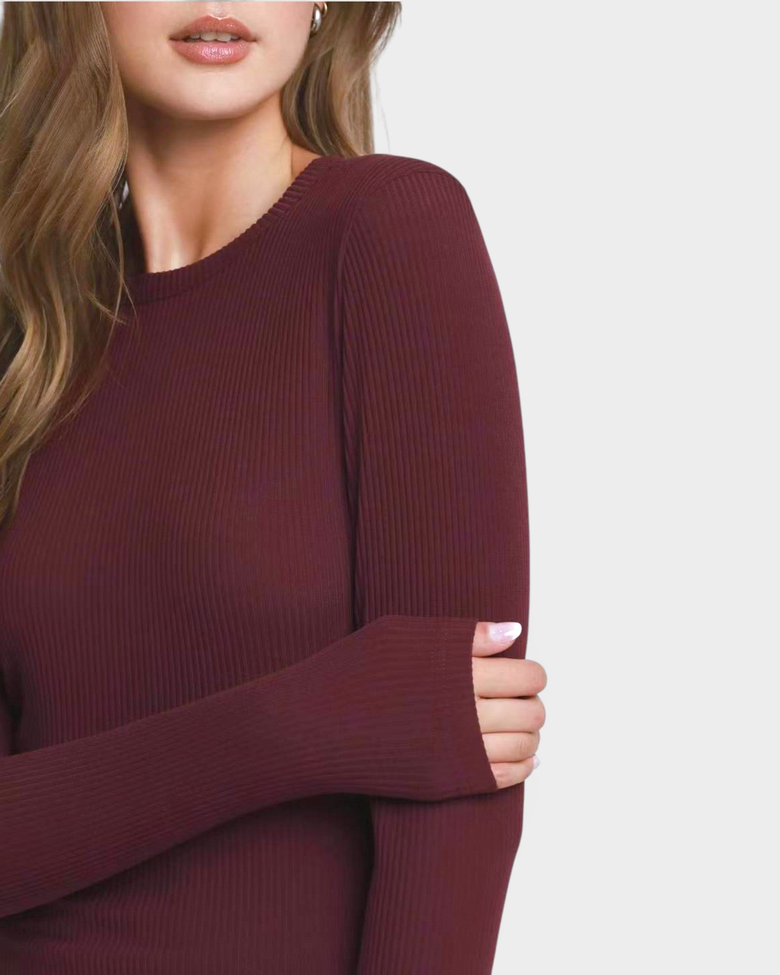 Maroon sweater worn by a person on a light gray background