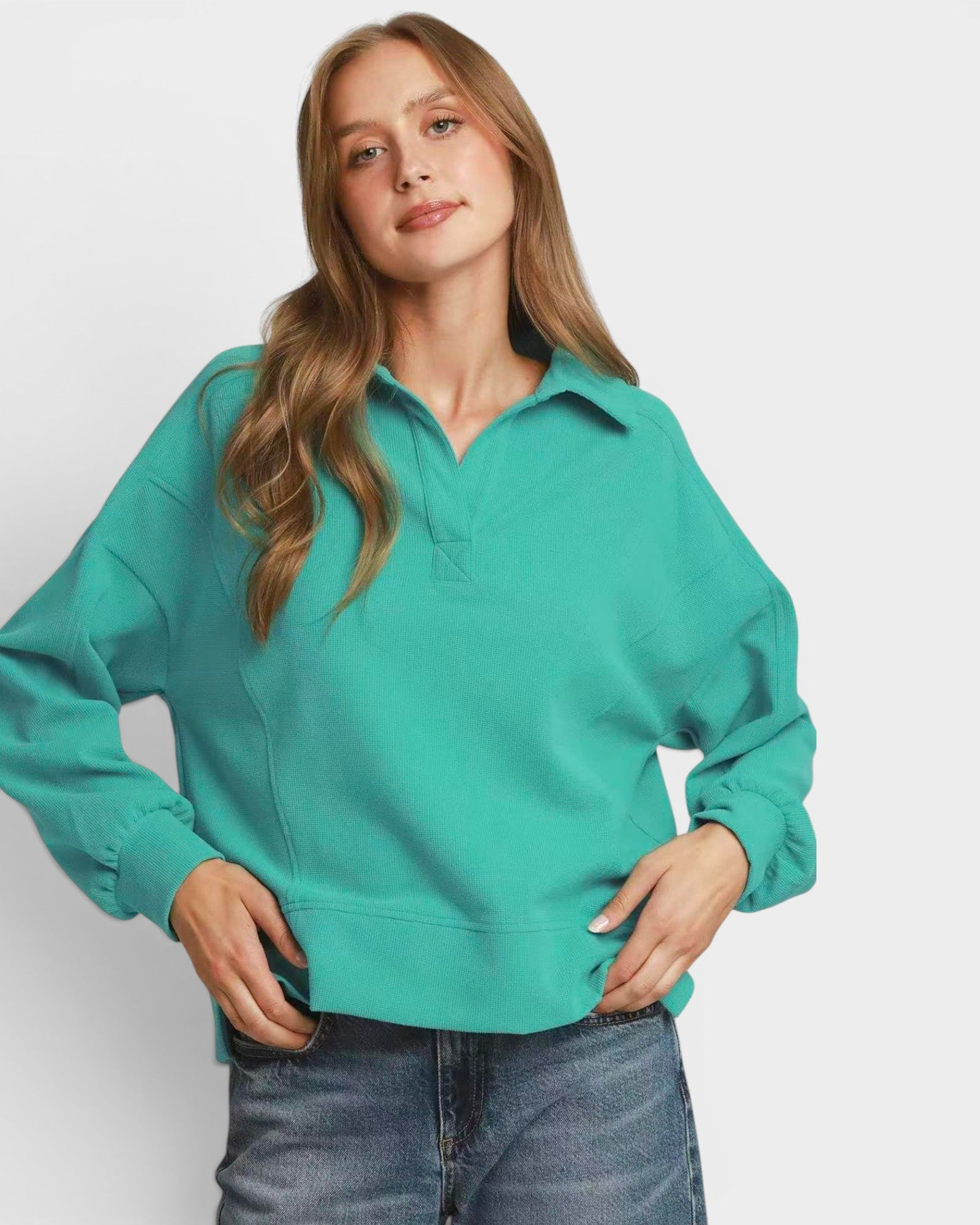 Person wearing a teal sweatshirt on a white background
