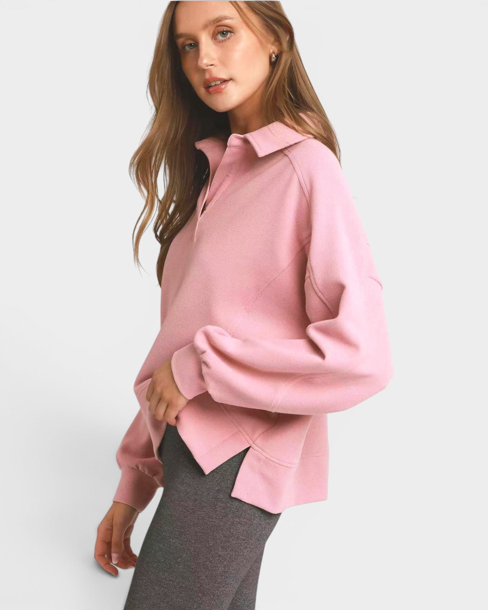 Woman wearing a pink sweatshirt with a white background
