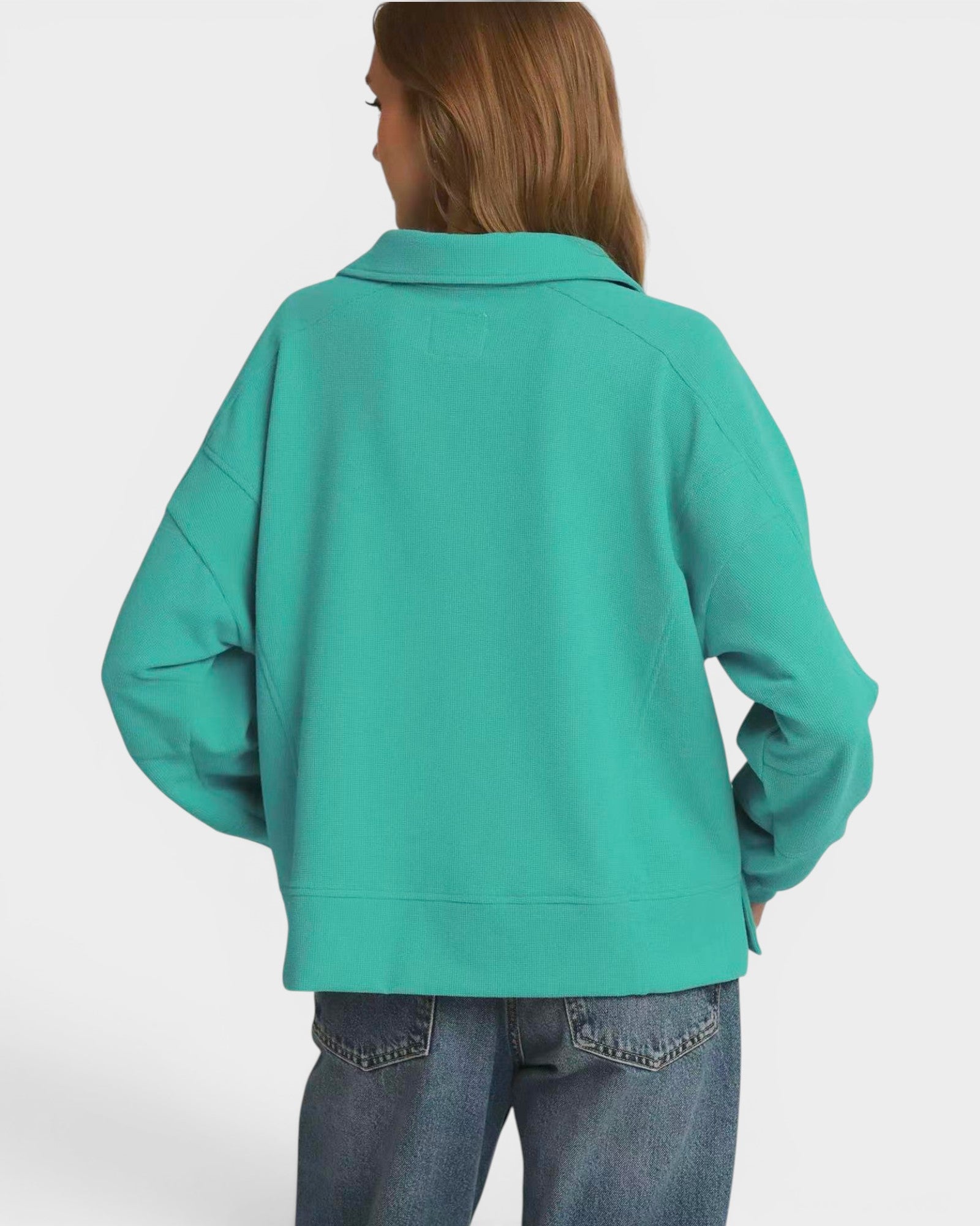 Person wearing a teal sweatshirt on a white background