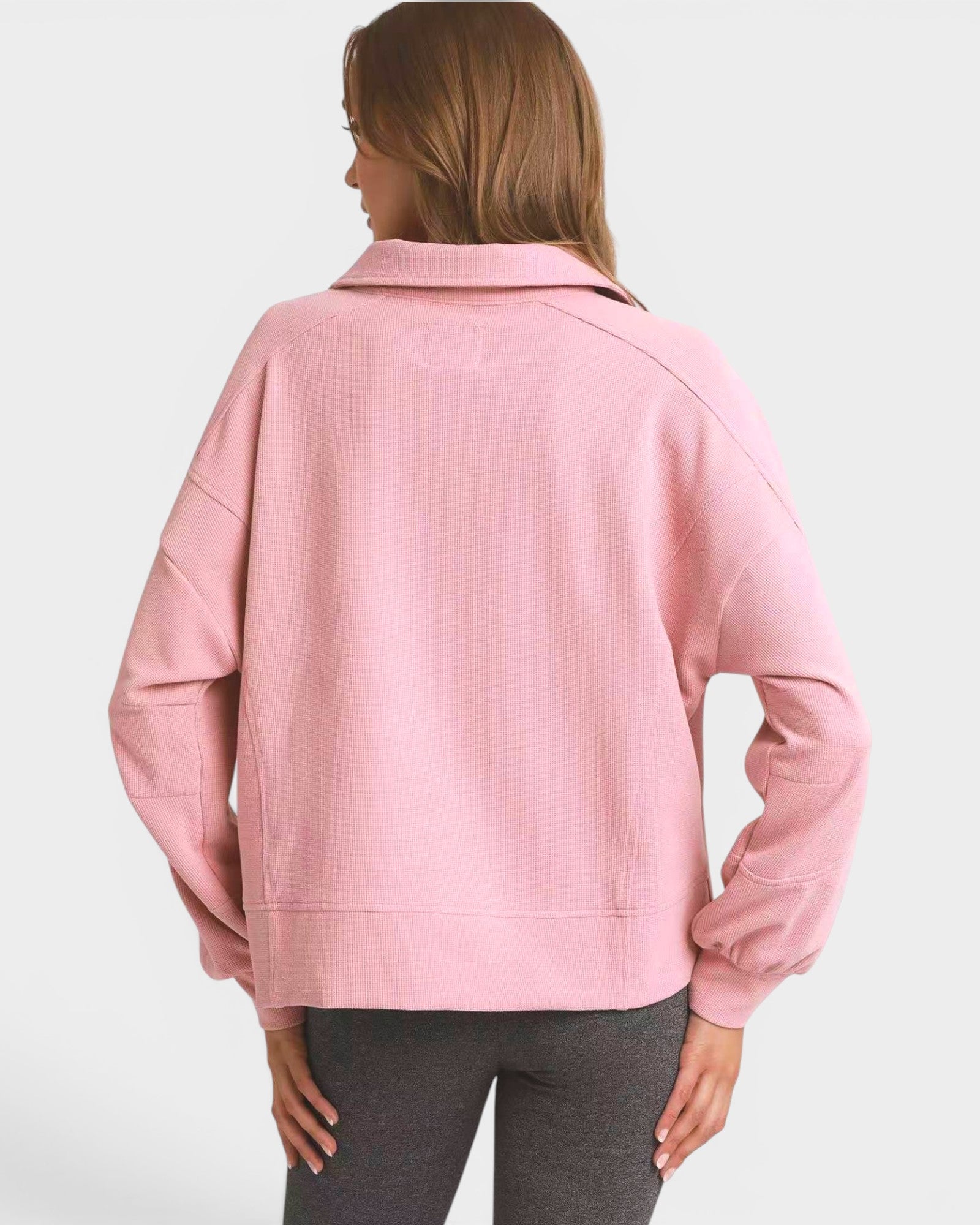Person wearing a pink sweatshirt on a white background