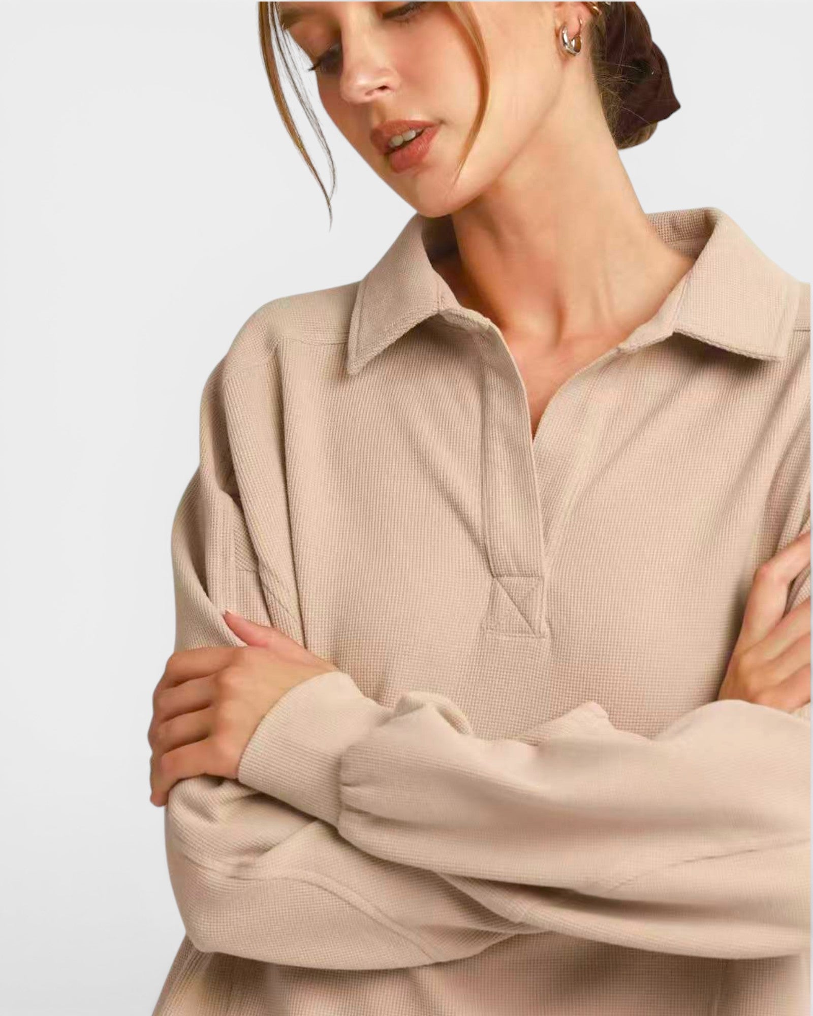 Woman wearing a beige long-sleeve shirt with a collar on a white background