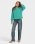 Person wearing a teal sweatshirt and blue jeans on a white background