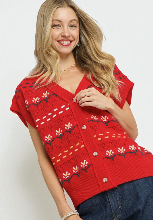 Woman wearing a red knitted vest with floral patterns on a white background