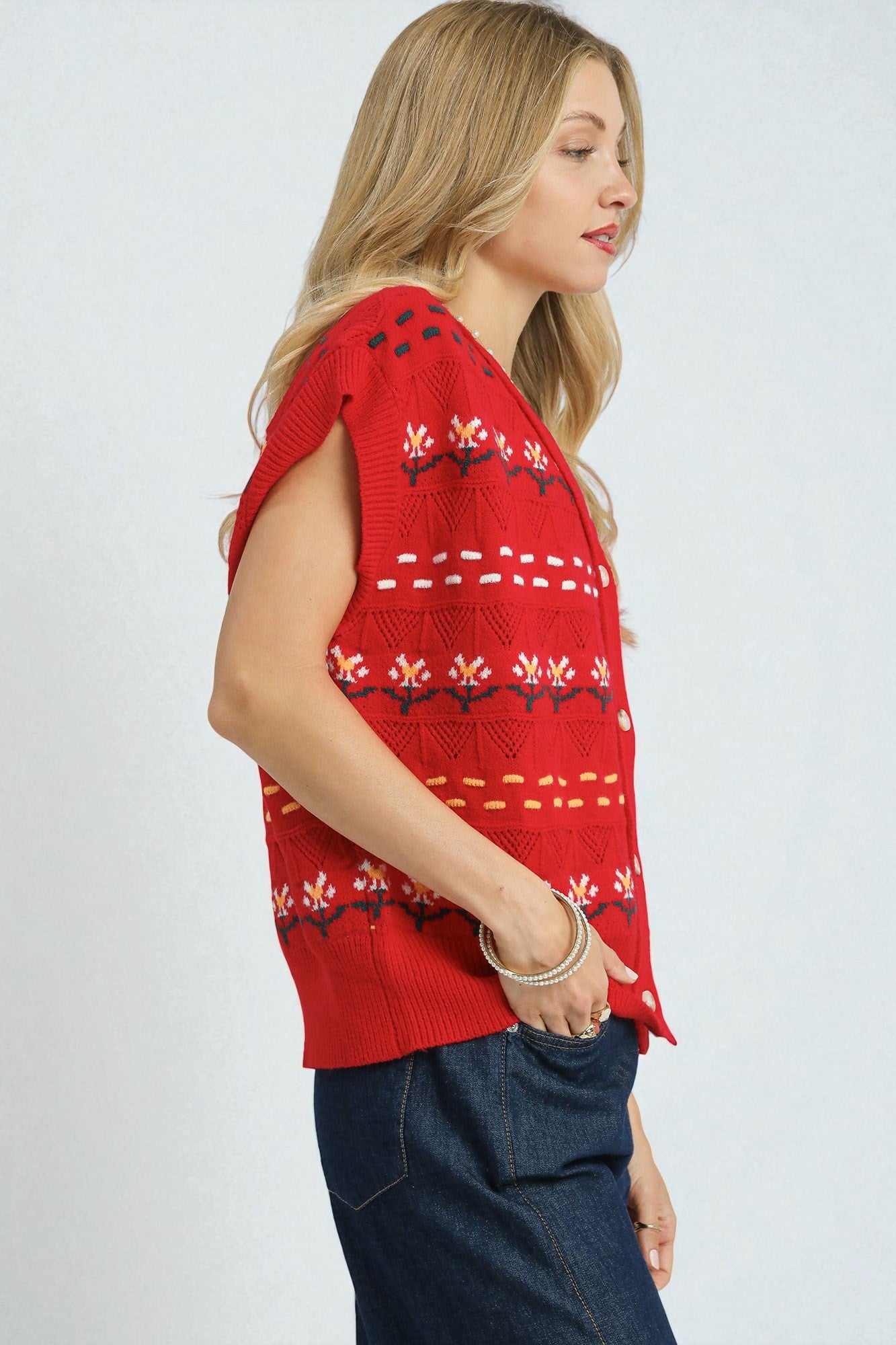 Woman wearing a red patterned sleeveless top against a white background