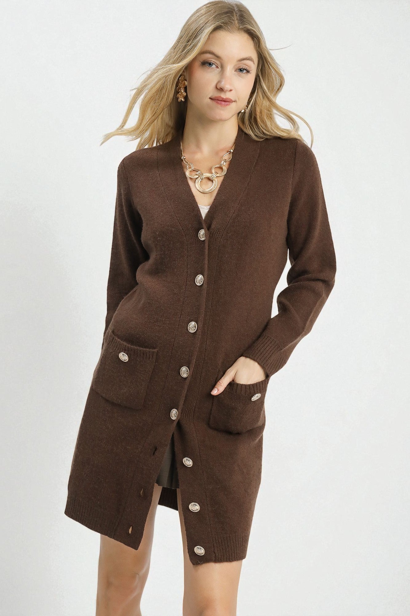 Woman wearing a brown cardigan with buttons on a white background