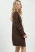 Woman wearing a brown cardigan over a white top on a white background