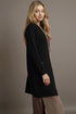 Woman wearing a black cardigan against a plain background