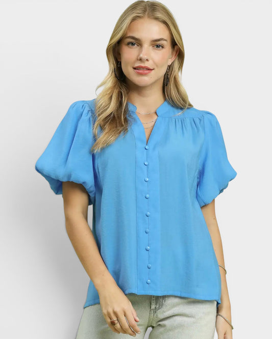 Woman wearing a blue blouse with short sleeves on a white background